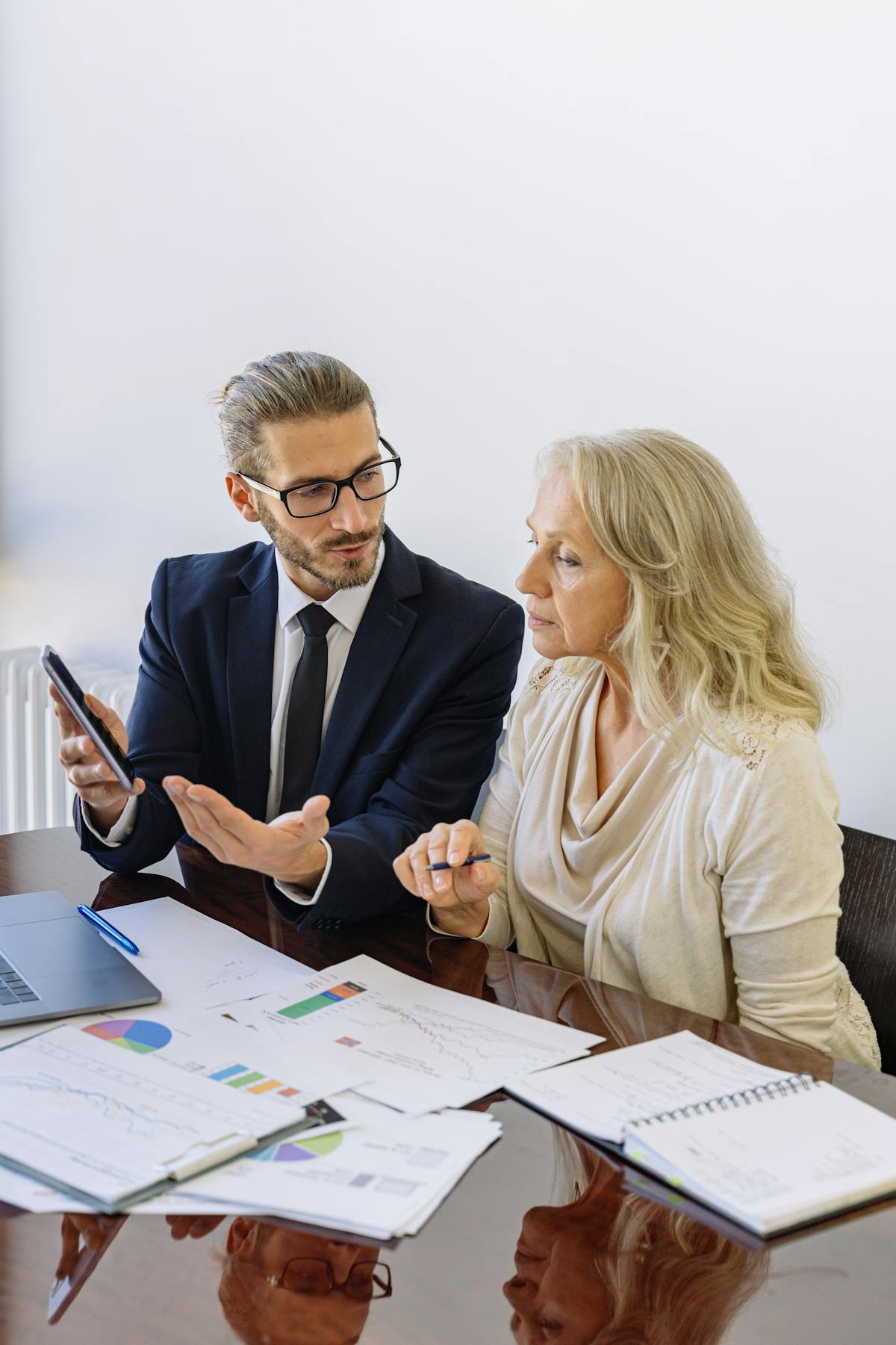 Professional consultant explaining a financial document to an adult client